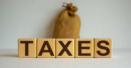 Concept word 'taxes' on cubes on a beautiful white background, Large canvas bag.の写真素材