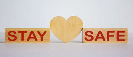 COVID-19 Pandemic Coronavirus concept. Wooden blocks with words stay home on white background. Wooden heart.の写真素材