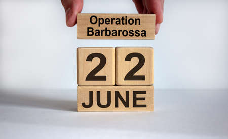 Male hand puts a block with the inscription 'operation barbarossa' on cubes with the date June 22th. Beautiful white background, copy space.の写真素材