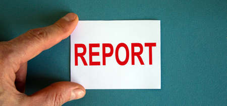 Word report on the white card between fingers.の写真素材