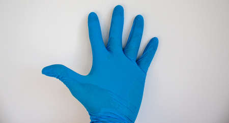 Doctor hand in sterile blue gloves. White background.の写真素材