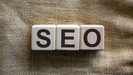 Wooden cubes form the word 'SEO' on beautiful canvas background.の写真素材