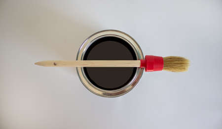 A round paint brush lies on a can of paint on a white background. Copy space.の写真素材