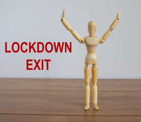 COVID-19 Pandemic Coronavirus and business concept. Wooden model of a man. Inscription 'lockdown exit'.の写真素材