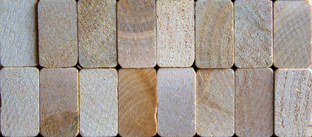 Photo of many small wooden cubes of different heights, tightly lying one after another, imitating...