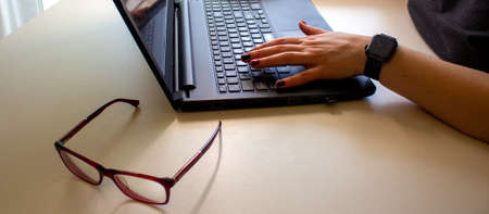 Work from home. Business woman hand working on blank screen laptop computer on white desk as...