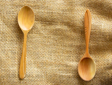 Two beautiful wooden spoons isolated on canvas background.の写真素材