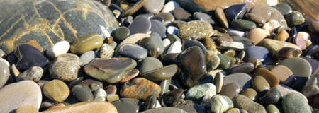 Pattern with turquoise sea stones beach on for design. Beautiful gravel background. Stone texture. Image For desktop, wallpapers, banner.の写真素材