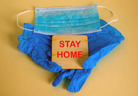 COVID-19 Pandemic Coronavirus concept. Medical mask on the latex gloves. Stay home inscription.の写真素材