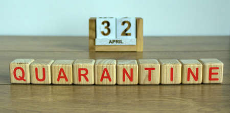 COVID-19 Pandemic Coronavirus concept. Wooden calendar whith abstract date 32 april. Inscription quarantine on wooden cubes.の写真素材