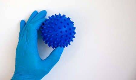 COVID-19 Pandemic Coronavirus concept. The doctor holds in his hand a abstract model of coronavirus....