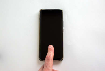 Man's finger unlocks a smartphone on the white background. Copy space for your text.の写真素材