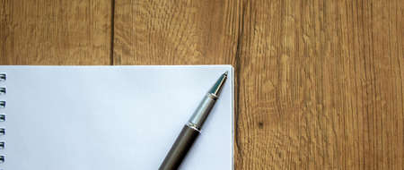 Notebook and pen on beautiful wooden table. Concept background.