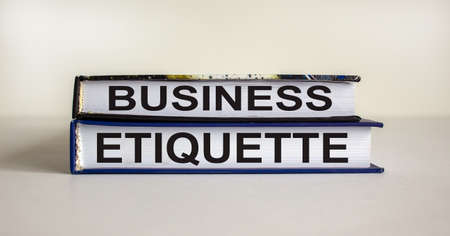 Books with text 'business etiquette' on beautiful white table. White background. Business concept....