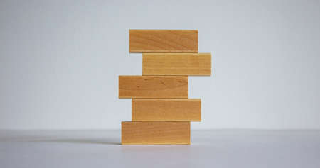 Concept of building success foundation. Stack of wooden blocks. Beautiful white background.