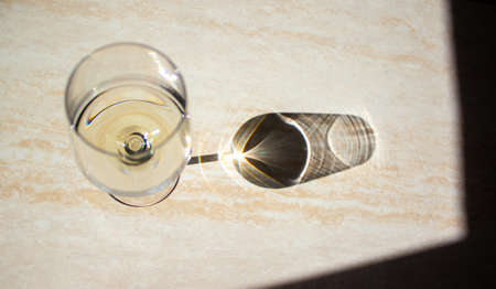 The shadow on the table from a glass of white wine. Concept.