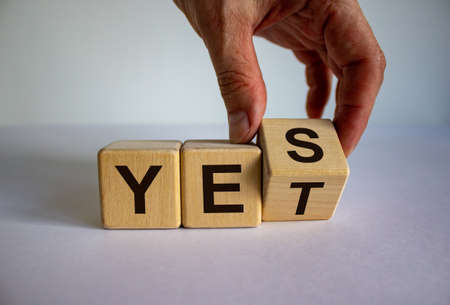 Male hand flips a cube and changes the expression YES to YET. Beautiful white background. Business...