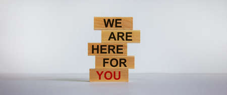 Wooden blocks with text 'we are here for you'. Beautiful white background, copy space. Business concept.の写真素材