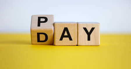 Turned a cube and changed the word 'Pay' to 'Day'. Beautiful yellow table. White background....