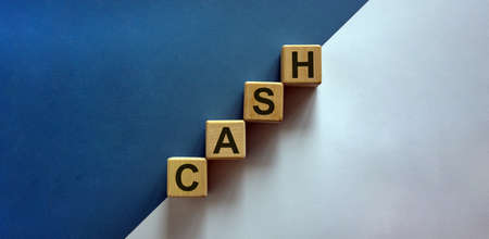 Wood block with word 'cash' stacking as step stair on paper blue and white background, copy space....