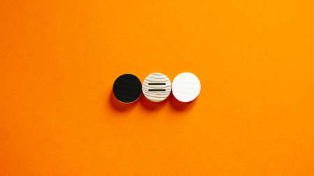 Racial equality concept. Black and white wood circles on beautiful orange background. Copy space.の写真素材