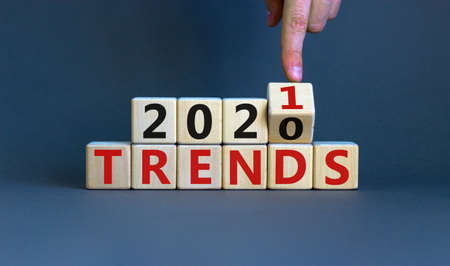 Business concept of planning 2021. Male hand flips wooden cube and change the inscription 'TRENDS...