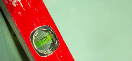Building tool level. Red water level tool isolated on green background. Concept. Copy space.