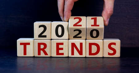 Business concept of planning 2021. Male hand flips wooden cubes and changes the inscription 'Trends...
