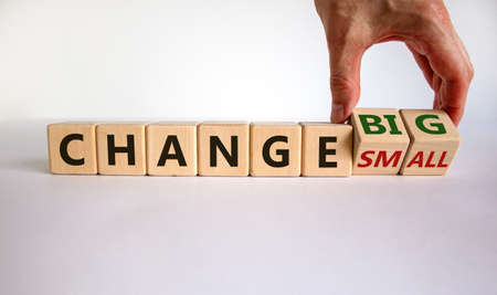 Male hand turns cubes and changes the expression 'change small' to 'change big' or vice versa....