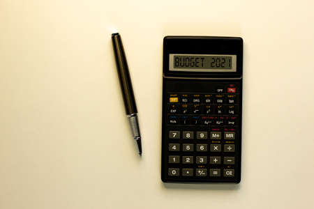 Business concept of planning 2021. Calculator with inscription 'budget 2021', metalic pen. Business...