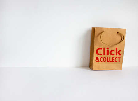 Disposable bag of kraft paper on a beautiful white background with expression 'Click and collect'....
