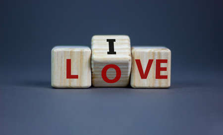 Live your love symbol. Turned cubes and changed the word 'live' to 'love'. Beautiful gray background, copy space. Business, live your love concept.の写真素材