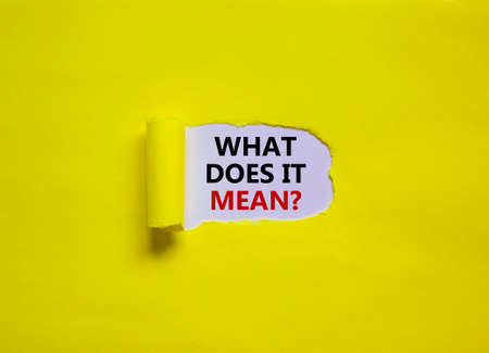 What does it mean symbol. Concept words 'what does it mean' appearing behind torn yellow paper....
