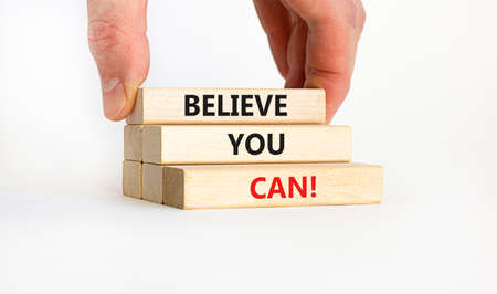 Believe you can symbol. Wooden blocks with words 'Believe you can'. Businessman hand. Beautiful white background. Copy space. Business, motivational and believe you can concept.の写真素材