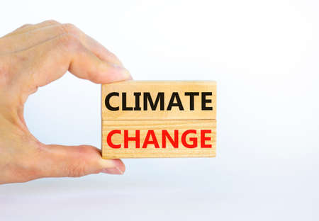 Climate change symbol. Wooden blocks with words 'Climate change' on beautiful white background. Businessman hand. Business, ecological and climate change concept. Copy space.の写真素材