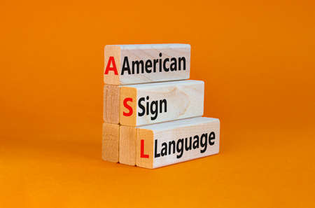ASL, american sign language symbol. Wooden blocks with words 'ASL, american sign language'. Beautiful orange background. Medical and ASL, american sign language concept. Copy space.の写真素材