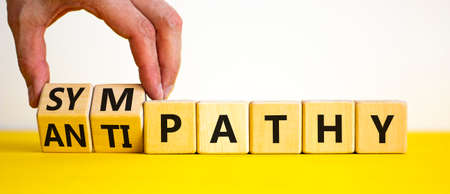 From antipathy to sympathy. Businessman turns cubes and changes the word 'antipathy' to 'sympathy'....