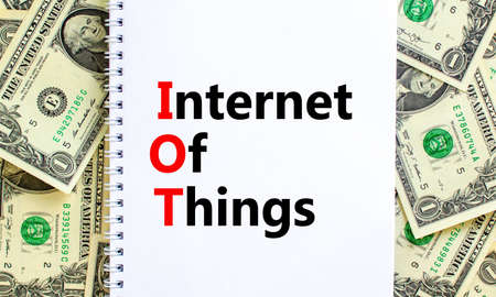 IOT, internet of things symbol. Words 'IOT, internet of things' on white note. Beautiful background from dollar bills. Business, digital, IOT, internet of things concept.の写真素材