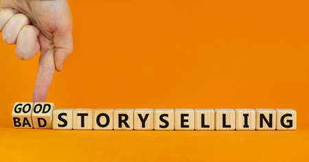 Good or bad storyselling symbol. Businessman turns wooden cubes, changes words 'bad storyselling' to...