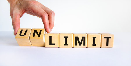 Limit or unlimit symbol. Businessman turns cubes, changes words 'limit' to 'unlimit'. Beautiful...