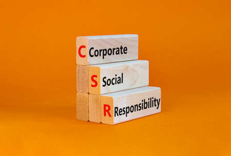Corporate social responsibility symbol. Concept words CSR, corporate social responsibility on blocks on a beautiful orange background. Business, corporate social responsibility concept. Copy space.の写真素材