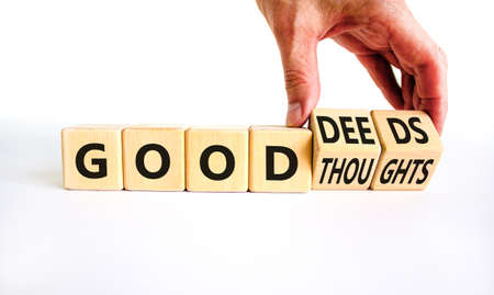 Good thoughts and deeds symbol. Businessman turns wooden cubes and changes words 'good thoughts' to 'good deeds'. Beautiful white background, copy space. Business and good thoughts and deeds concept.の写真素材