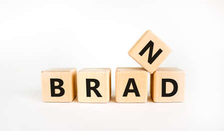 Brand symbol. The concept word 'brand' on wooden cubes on a beautiful white table, white background....