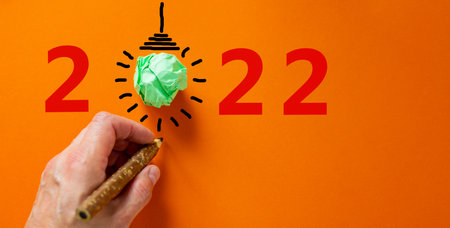 2022 happy new year symbol. Number 2022. Businessman hand with black pen, green light bulb icon....