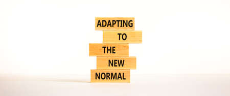 Adapting to the new normal symbol. Wooden blocks with words Adapting to the new normal on beautiful white background, copy space. Business, new normal concept.の写真素材