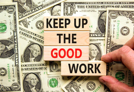 Keep up the good work symbol. Concept words Keep up the good work on wooden blocks. Businessman hand. Beautiful background from dollar bills. Keep up the good work business concept. Copy space.の写真素材