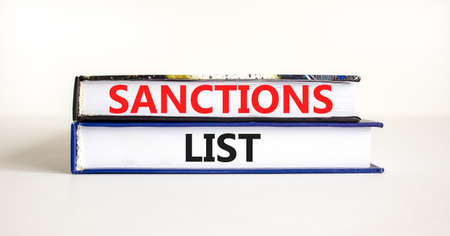 Sanctions list symbol. Books with concept words Sanctions list on beautiful white background. Business political sanctions list concept. Copy space.の写真素材