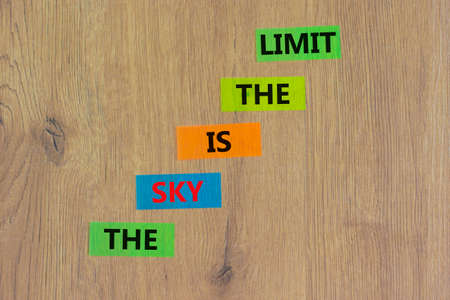 Sky is limit symbol. Concept words The sky is the limit on colored paper. Beautiful wooden table wooden background. Business motivational stress spice of life concept. Copy space.の写真素材