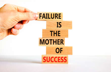 Failure or success symbol. Wooden blocks with words A failure is the mother of success. Beautiful white table white background. Businessman hand. Business, failure or success concept. Copy space.の写真素材