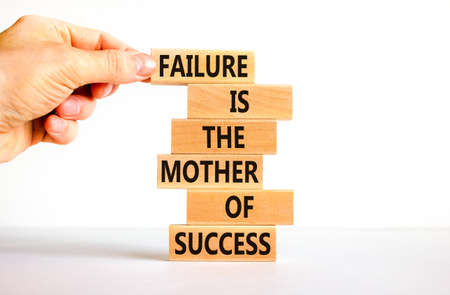 Failure or success symbol. Wooden blocks with words A failure is the mother of success. Beautiful white table white background. Businessman hand. Business, failure or success concept. Copy space.の写真素材